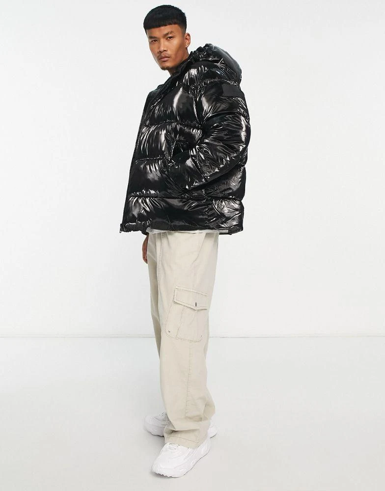 商品Calvin Klein|Calvin Klein Jeans badge logo high shine oversized puffer jacket in black ,价格¥2627,第4张图片详细描述