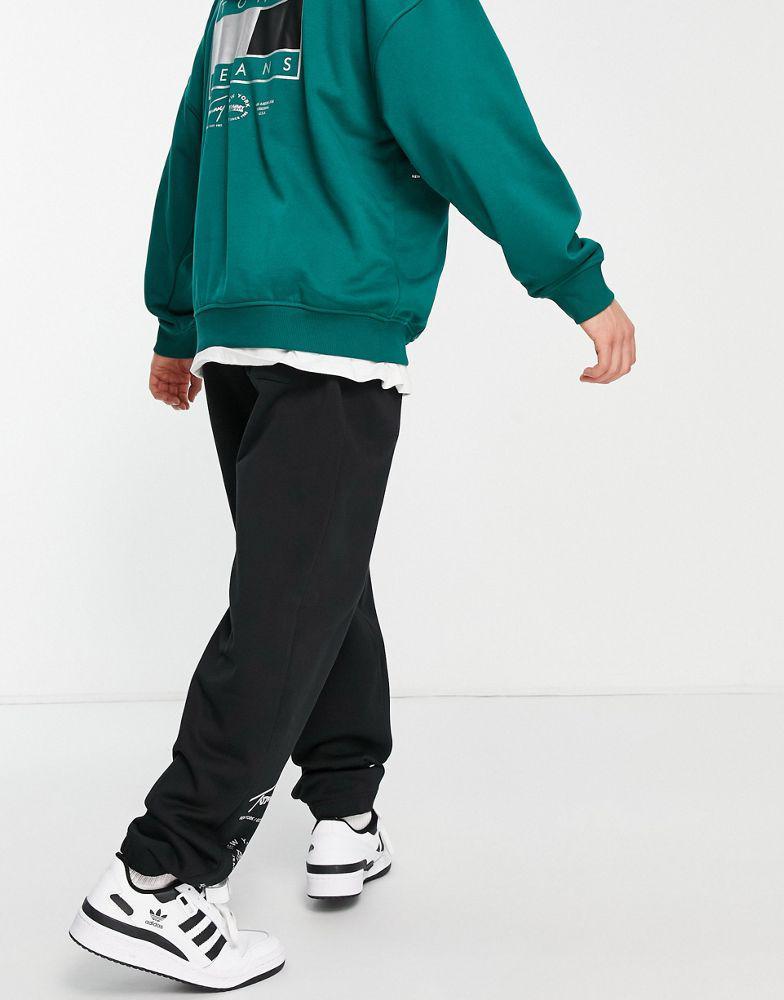 商品Tommy Hilfiger|Tommy Jeans Metallic capsule flag and leg print joggers in black,价格¥428,第4张图片详细描述